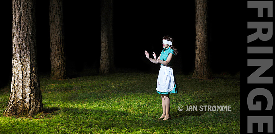 Surreal image of a blindfolded woman standing in a forest at night