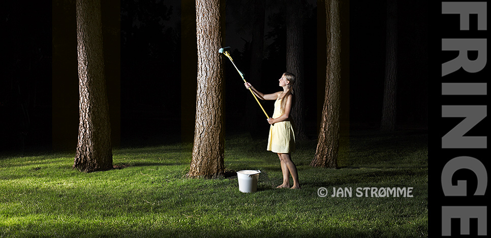 A photograph of a young woman using a mop to clean a forest at night