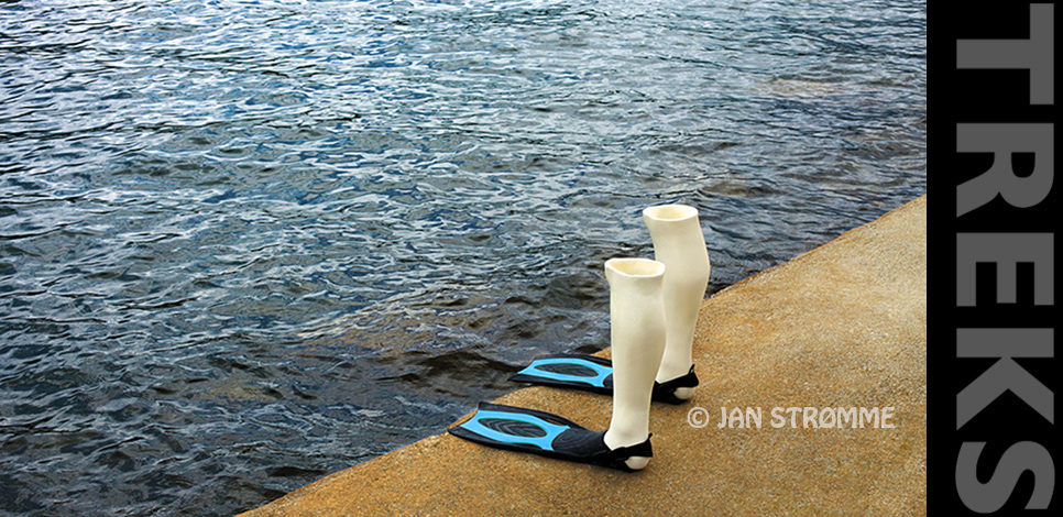 A pair of manikin legs wearing swim fins standing by a lake.